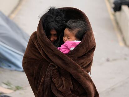 Una migrante venezolna con su hija en brazos se protege del frío en la ciudad de Matamoros (México), el 23 de diciembre de 2022.