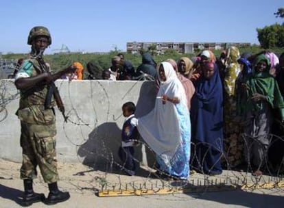 Un soldado de la Misión de la UA para Somalia abre el paso al cuartel para que varios ciudadanos sean vistos por un médico