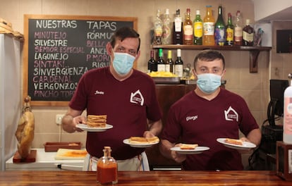 Juan y Giorgi, camarero y cocinero de La Casa de Los Minutejos con sándwiches recién hechos.