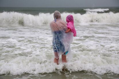 Una mujer con su hija en brazos en la playa de Clearwater Beach en Florida (EE UU). La tormenta tropical Hermine sigue fortaleciéndose en aguas del Golfo de México y alcanzará la costa noroeste de Florida (EEUU) convertida en un huracán, informó el Centro Nacional de Huracanes (NHC) de Estados Unidos.