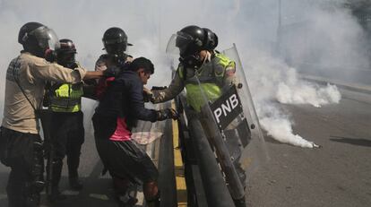 Agentes de las fuerzas de seguridad venezolanas agreden a un manifestante.