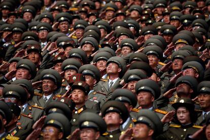 Oficiales del ejército norcoreano saludan a la bandera del país durante el desfile militar.