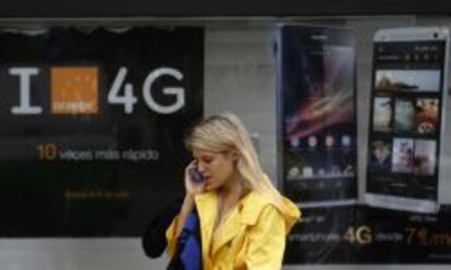 Usuaria de m&oacute;vil ante una publicidad de 4G de Orange.