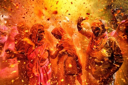 Varias viudas se lanzan polvos de colores y pétalos de flores durante la celebración del festival Holi en la ciudad de Vrindavan (India).