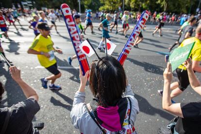 Una aficionada japonesa anima a los corredores.