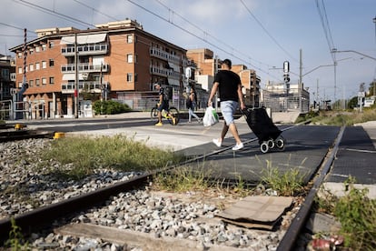 Un peatón cruza las vías de tren en Montcada.