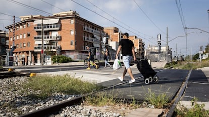 Un hombre cruza las vías de tren pese a las señales de prohibición, en Montcada.