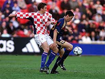 Melli controla el balón ante la oposición de un jugador croata.
