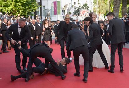 Los agentes de seguridad atrapan al hombre que ha conseguido entrar en el alfombra roja.