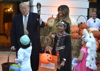 Donald J. Trump, junto a su esposa, Melania, sostiene un bastón con forma de cobra mientras bromea con los niños que acuden a la Casa Blanca para celebrar Halloween, el domingo 28 de octubre.