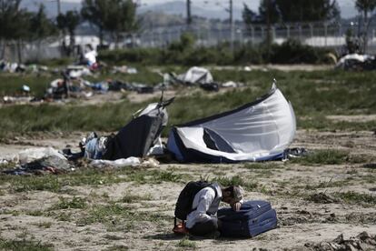 Un refugiado kurdo espera su traslado a un centro de acogida durante la operación policial de desalojo en Idomeni (Grecia), que comenzó hace dos días.