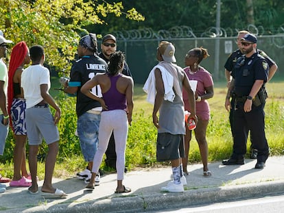 Testigos hablan con oficiales de policía cerca de la escena del crimen donde sucedió un tiroteo masivo en Jacksonville, Florida.