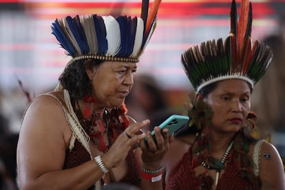 Indigenous women from the Tupinamba tribe use a mobile phone during a ceremony at the National Museum in Rio de Janeiro, September 12, 2024.