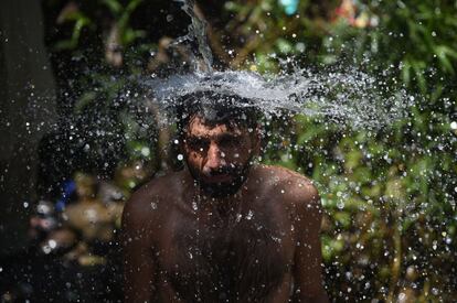 Un paquistan se ba?a bajo un chorro de agua en Islamabad (Pakistn).