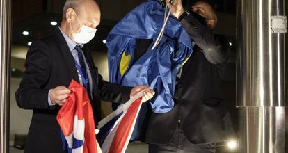 Dos empleados de la Comisión Europea sustituyen banderas de la Unión y de Reino Unido en el exterior del edificio. 