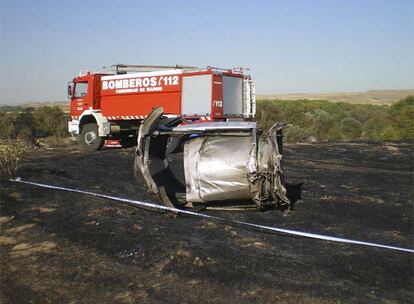 Delante del camin de bomberos, los restos de la turbina derecha del MD-82 con uno de los  sistemas de freno del avin, la reversa (la parte metlica que sobresale a la izquierda del motor), desplegada.