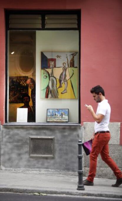 Un joven frente al escaparate de la galería Orfila.