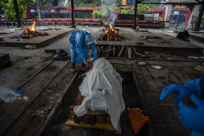 Familiares de un fallecido por coronavirus últiman los preparativos para su cremación, en un tanatorio de Nueva Delhi (India). India ha sumado en las últimas horas más de 37.000 nuevos casos de coronavirus, con lo que ya ha completado una semana registrando más de 30.000 positivos diarios, si bien este miércoles también ha anotado la mayor cifra diaria de personas recuperadas, más de 28.000.