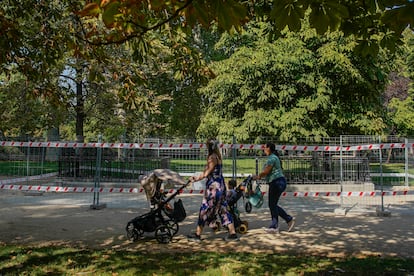 Dos mujeres con carrito pasean por el parque de El Retiro en Madrid.