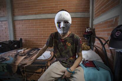 Un joven venezolano de15 años posa con una mascara decorada por el en un albergue de Ciudad de México.