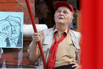 Un hombre porta una caricatura de los presidentes rusos Yeltsin y Putin, durante un homenaje al frustrado intento de golpe de estado de hace 15 años.