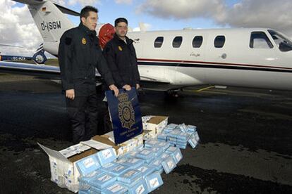 Dos agentes de la Policía Nacional muestran la droga incautada, más de 106 kilogramos de cocaína, junto al aparato utilizado para su transporte desde Guinea-Bissau.