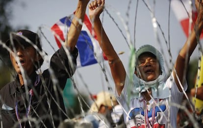 Manifestantes antigubernalentales tras una barricada en Bangkok.