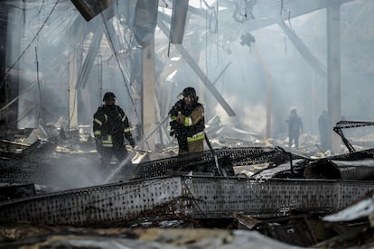 Bomberos trabajan sobre los escombros del supermercado destruido por el impacto de un misil, este viernes.