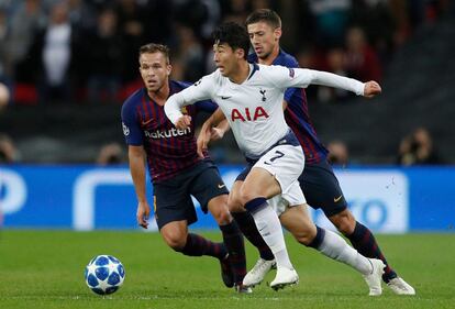 El jugador coreano del Tottenham Son Heung-Min se lleva el balón ante el centrocampista del Barcelona, Paulinho.