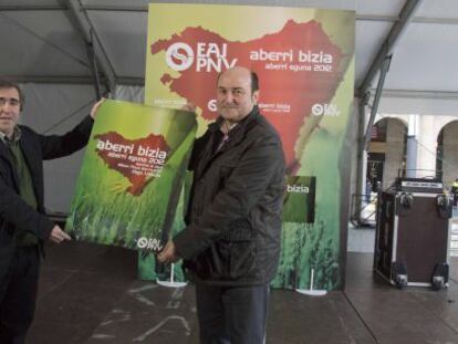 Andoni Ortuzar (derecha) y el también miembro del EBB Joseba Aurrekoetxea sostienen el cartel anunciador del Aberri Eguna de su partido. 