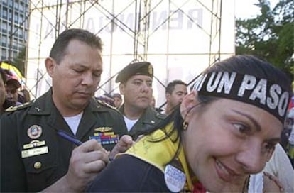 El coronel Aguedo Rogelio d'Hoy firma un autógrafo a una oponente al presidente venezolano Chávez.