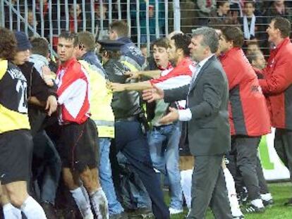 Entrenador y jugadores del Eindhoven ayudan a desalojar a los hinchas.