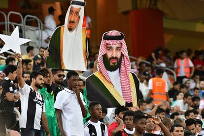 Aficionados en la grada llevan retratos del rey saudita Salman y el príncipe heredero Mohammad Bin Salman antes de la final de Supercoppa Italiana entre Juventus y AC Milan en el Estadio de la Ciudad Deportiva King Abdullah, en Yeda (Arabia Saudito).