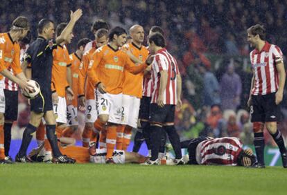 Los jugadores del Athletic de Bilbao y del Valencia rodean a Fernando Llorente y David Navarro ambos en el suelo durante el partido.