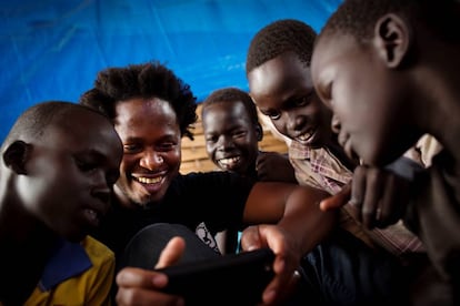 El 26 de noviembre de 2015, Ishmael Beah, ex niño soldado, muestra algunas fotos de su móvil a niños en un centro de protección de la infancia en Juba, Sudán del Sur.