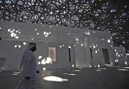 Um servidor público dos Emirados Árabes Unidos caminha baixo a cúpula do Louvre de Abu Dhabi. A majestosa cúpula de 180 metros de diâmetro e 7.500 toneladas que cobre o complexo está perfurada por estrelas de formas irregulares, que deixam entrar o sol criando reflexos caprichosos no pátio nos entornos do o museu.