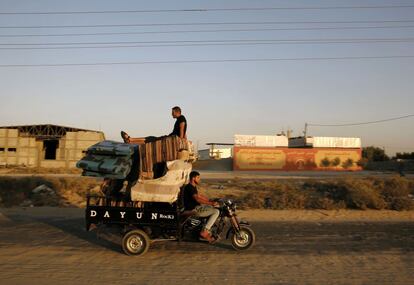 Un palestino conduce un triciclo cargado con sofás y colchones en Beit Hanun (Franja de Gaza).