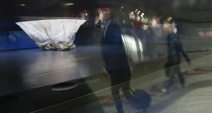 Pasajeros de la estación de Atocha, frente a la cúpula de plástico desplomada del monumento.