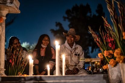 Una familia junto a la tumba de uno de sus seres queridos, en San Pedro Tláhuac.