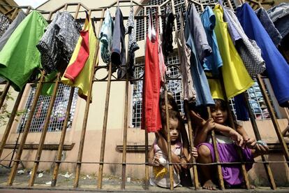 Niños filipinos que se han quedado sin casa juegan mientras esperan el reparto de ayuda humanitaria en un gimnasio en Manila (Filipinas).