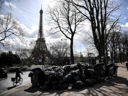 Peatones y ciclistas pasan junto a una montaña de basura en los alrededores de la Torre Eiffel este miércoles.