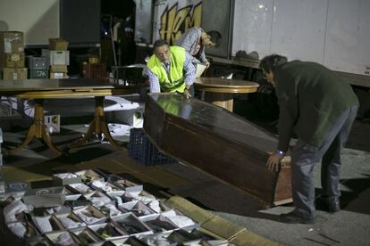 Dos vendedores colocan un ataúd para la subasta, el viernes por la madrugada.