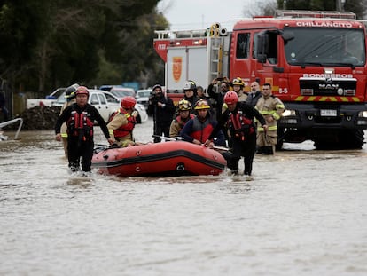 Bomberos trabajan en un área inundada por las fuertes lluvias en Cabrero, Chile.