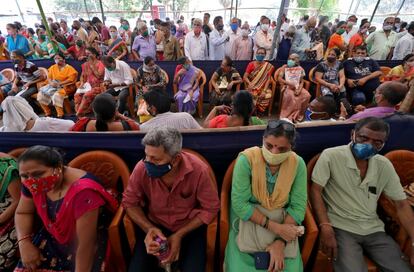 Decenas de personas esperan para recibir la vacuna contra el coronavirus en un centro de vacunación en Bombay (India).