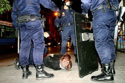 Una de las personas detenidas en la zona centro tras la manifestación antifascista, rodeada de agentes antidisturbios.