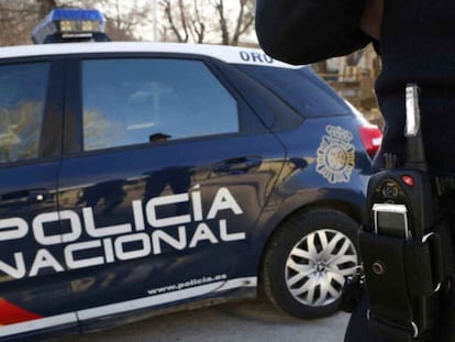 Un agente y un coche patrulla de la Policía Nacional de Valladolid.
