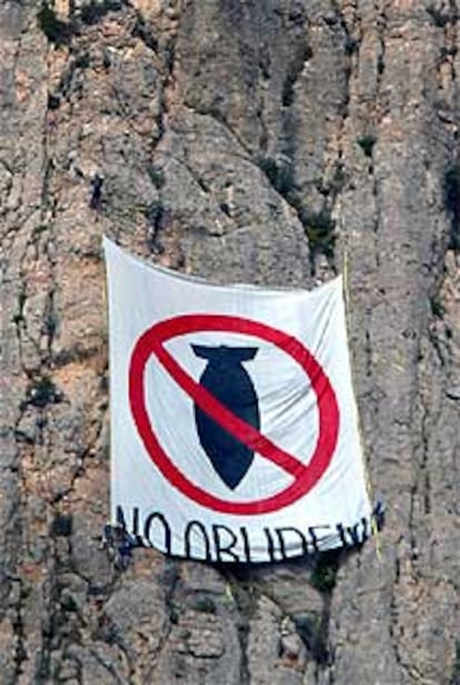 Integrantes de la Plataforma per la Pau despliegan una pancarta contra la guerra ayer en Montserrat.