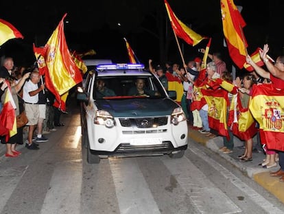 Un grup de persones acomiaden a agents de la Guàrdia Civil que viatgen cap a Catalunya.