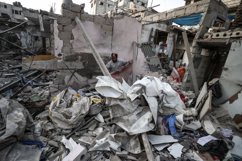 Varias personas examinan los escombros de edificios gravemente dañados tras los ataques israelíes contra el campo de refugiados de Maghazi, en Deir al Balah, en el centro de la franja de Gaza, este martes. 