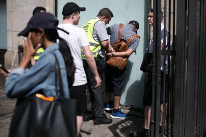 Agentes de seguridad privada del mercado de la Boqueria detienen a un carterista tras robar a unos turistas rusos.